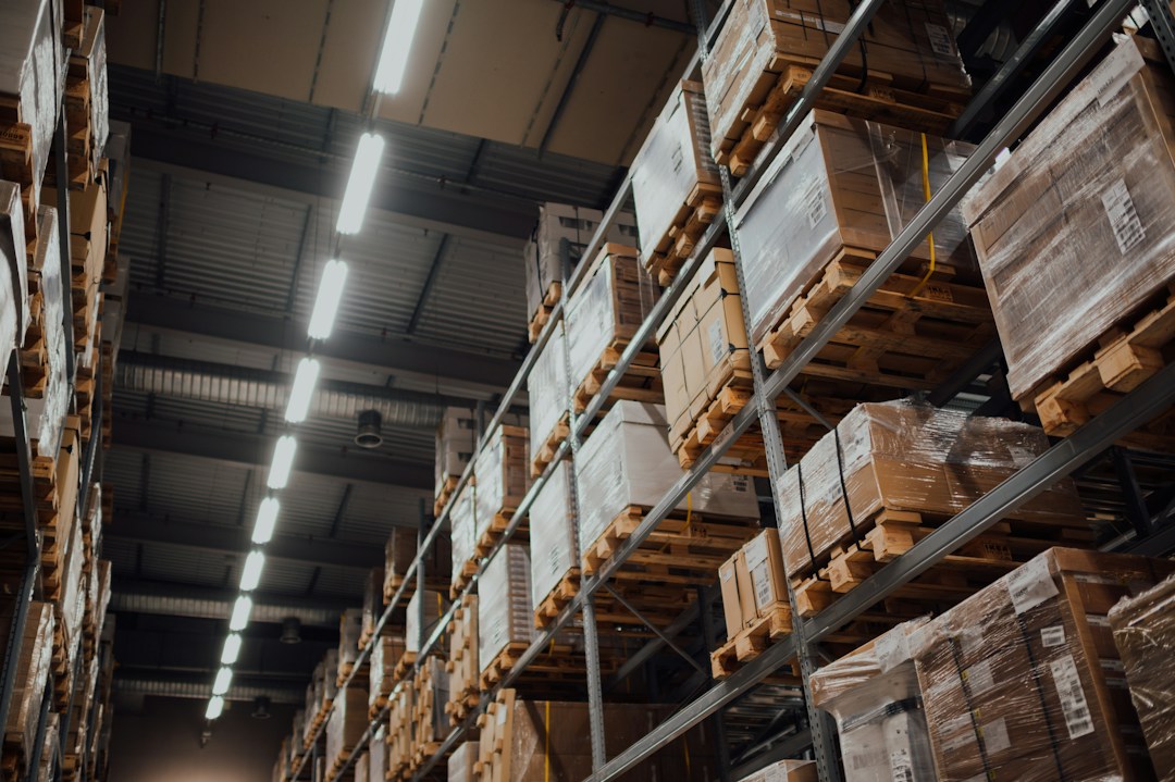 Brown cardboard boxes stacked on white metal warehouse shelves